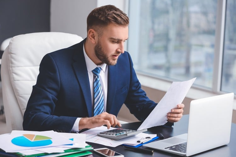 Accountant reviewing financial documents at his desk